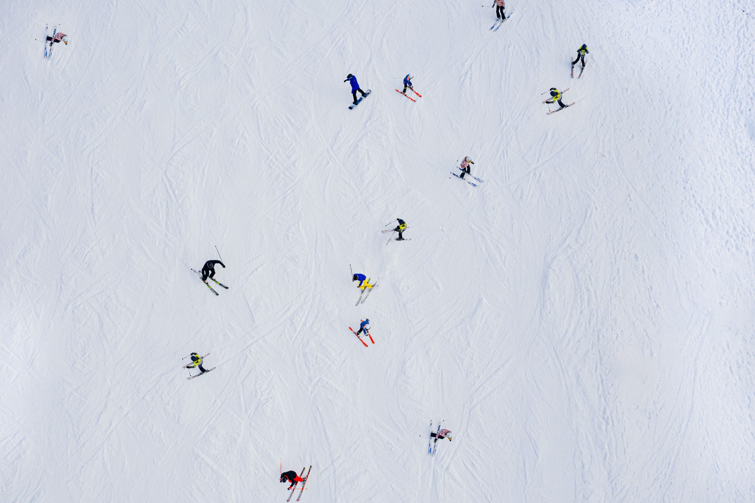 aerial view skiers on mountain slope scaled