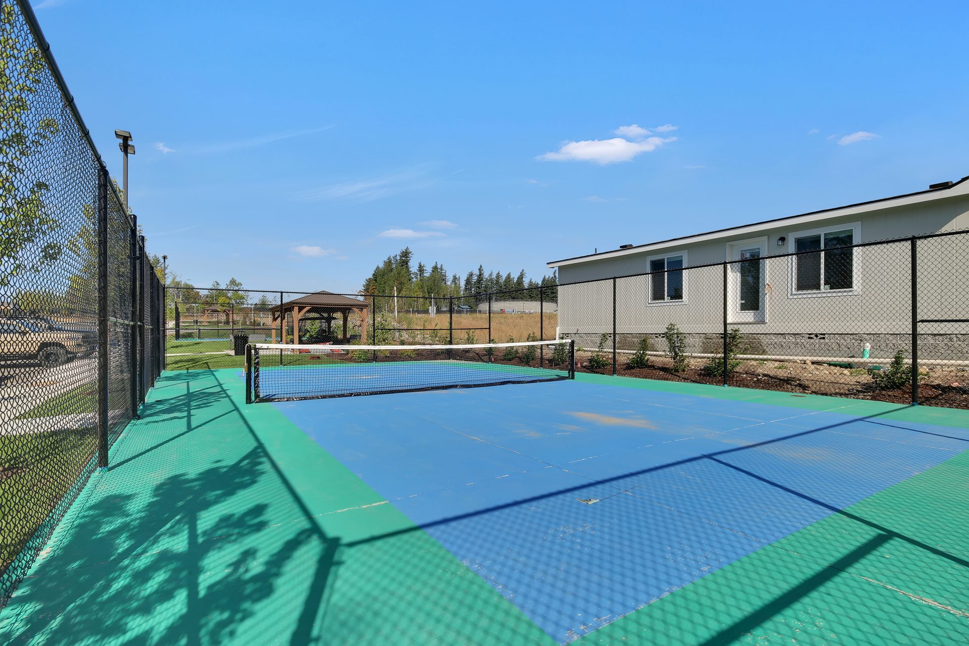 enclosed blue surface pickleball court