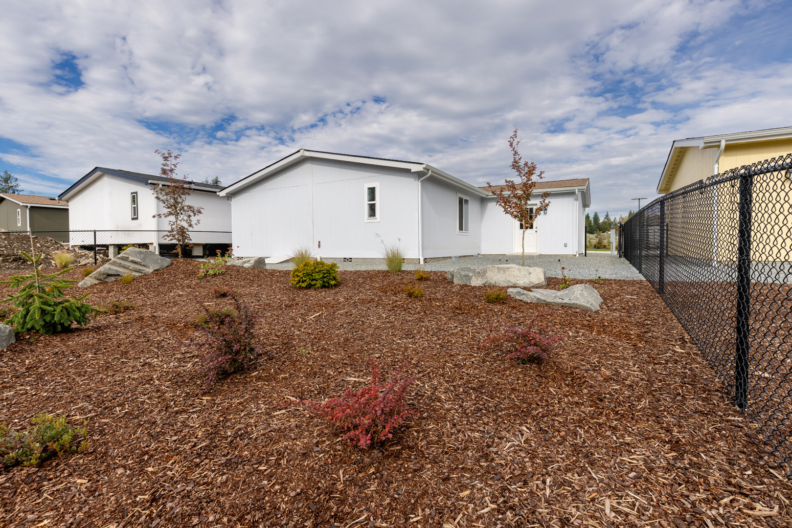 white modular residence with mulched yard